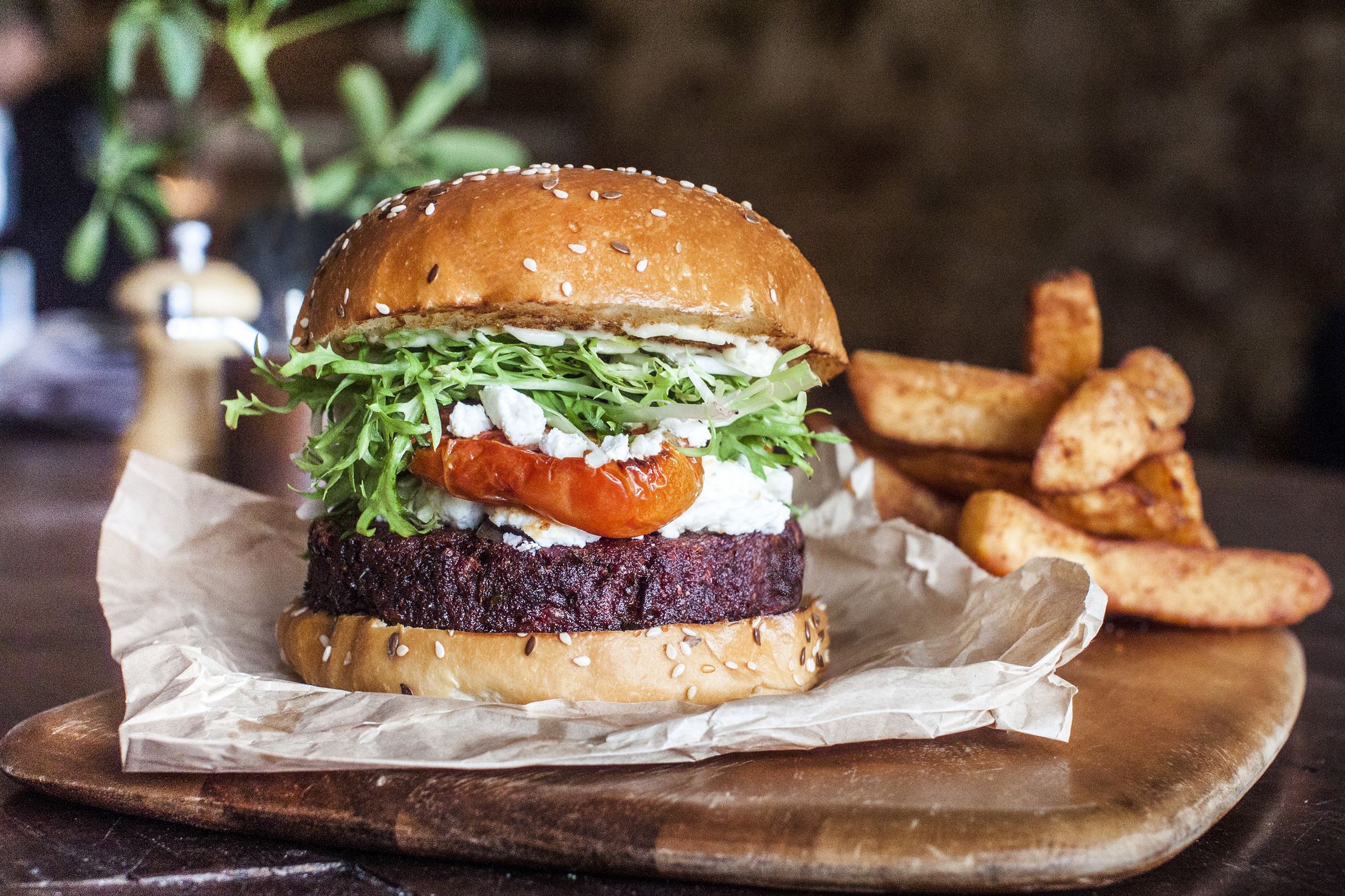 Burger with rocket and roasted tomato, served with chips