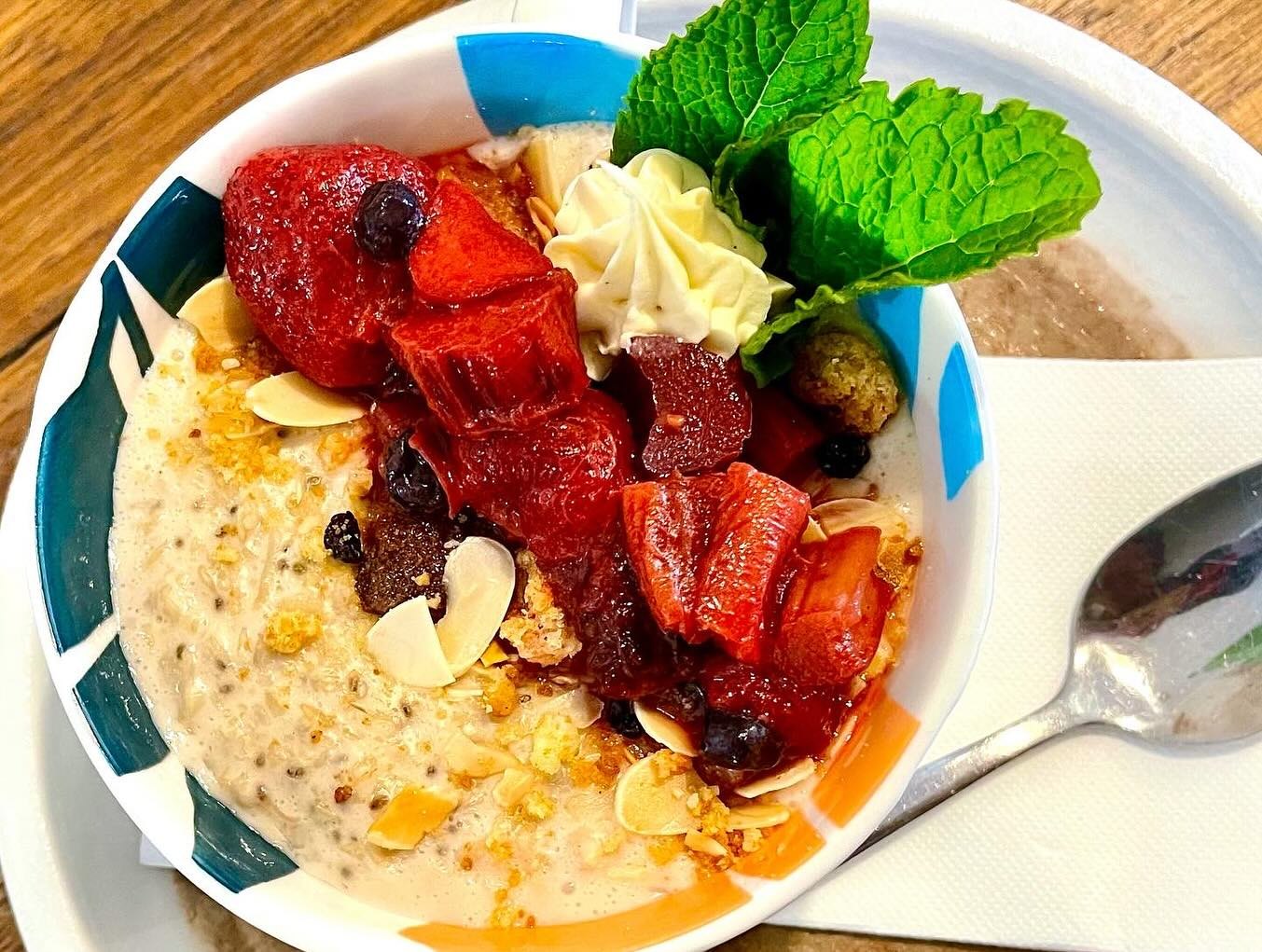 Cinnamon oat porridge with red fruit compote, almonds and mint
